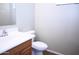 Powder room featuring a white toilet, sink, and vanity with dark wood at 4114 S Sawmill Rd, Gilbert, AZ 85297