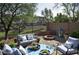 Inviting backyard patio with outdoor seating, a fire pit, and lush landscaping at 4114 S Sawmill Rd, Gilbert, AZ 85297