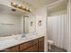 Well-lit bathroom with a large mirror, sink, vanity and a shower with curtain at 4215 W Griswold Rd, Phoenix, AZ 85051