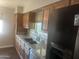 Kitchen with wood cabinets, granite counters, and stainless steel appliances at 5150 N 20Th St # 201, Phoenix, AZ 85016