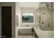 Modern bathroom featuring a soaking tub and a glass-enclosed shower with dual shower heads at 5327 N Invergordon Rd, Paradise Valley, AZ 85253