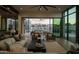 Indoor/outdoor living space with a large sectional, patio view, and modern desert landscaping at 5327 N Invergordon Rd, Paradise Valley, AZ 85253