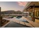 A luxurious backyard features a pool, a view of the mountains, and an outdoor dining and grilling area at 5327 N Invergordon Rd, Paradise Valley, AZ 85253