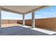A covered backyard patio featuring a concrete slab, tan columns, and a brown brick fence at 564 E Aurora Dr, San Tan Valley, AZ 85140