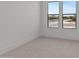 Bright, empty bedroom with plush carpeting and large windows with neighborhood views at 564 E Aurora Dr, San Tan Valley, AZ 85140