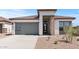Attractive single-story home showcasing a modern garage door, stone accents and desert landscaping at 564 E Aurora Dr, San Tan Valley, AZ 85140