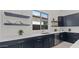 Modern kitchen featuring navy blue cabinets, sleek countertops, stainless steel appliances and ample natural light at 564 E Aurora Dr, San Tan Valley, AZ 85140