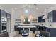 Stylish kitchen with navy blue cabinets, a central island, modern lighting and high-end appliances at 564 E Aurora Dr, San Tan Valley, AZ 85140