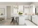 White kitchen with center island, breakfast bar, and stainless steel appliances at 564 E Aurora Dr, San Tan Valley, AZ 85140