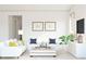 Bright living room with white sofa, white coffee table, and large windows at 564 E Aurora Dr, San Tan Valley, AZ 85140