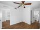 Bright bedroom with wood-look flooring, ceiling fan, and access to a bathroom at 10024 W Montecito Ave, Phoenix, AZ 85037