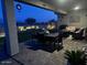 Evening view of a covered patio with seating and outdoor dining at 15047 S 178Th Dr, Goodyear, AZ 85338