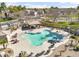 Aerial view of the community pool with ample seating, cabana and lush landscaping with palm trees, great for relaxation and recreation at 1578 S Sabino Ct, Gilbert, AZ 85296