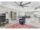 Cozy living room area with a large ceiling fan, sliding glass doors to the backyard, and an armchair at 1578 S Sabino Ct, Gilbert, AZ 85296