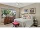 Bright bedroom with a queen bed, a large window showcasing outside greenery, and decorative pillows at 16954 W Palm Ln, Goodyear, AZ 85395