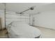 Clean garage with a car cover with BMW written on it, ladder, white walls, and plenty of space for storage at 16954 W Palm Ln, Goodyear, AZ 85395