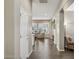 Inviting hallway with wood floors and neutral walls leading to a living area with bright windows at 16954 W Palm Ln, Goodyear, AZ 85395