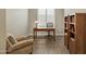 Cozy home office featuring a wooden desk, bookshelves, and comfortable armchair at 16954 W Palm Ln, Goodyear, AZ 85395