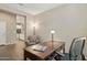 Functional home office space featuring a desk with a chair and an adjacent living space at 16954 W Palm Ln, Goodyear, AZ 85395