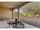 Covered outdoor patio with wrought iron table and chairs offering serene views at 16954 W Palm Ln, Goodyear, AZ 85395