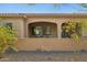 Cozy covered patio with privacy wall, outdoor seating, and manicured landscaping for relaxation at 16954 W Palm Ln, Goodyear, AZ 85395