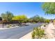 Community entrance with lush landscaping and mature trees on a sunny day at 17763 N 93Rd Way, Scottsdale, AZ 85255