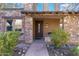 Home's inviting entryway with stone facade and wood door at 17763 N 93Rd Way, Scottsdale, AZ 85255