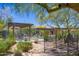 Outdoor pool area with shaded seating surrounded by lush landscaping and mature trees at 17763 N 93Rd Way, Scottsdale, AZ 85255