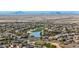 Aerial view of a community with houses, golf course, and lake at 26686 W Piute Ave, Buckeye, AZ 85396