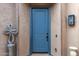Front entry with blue door, stone accents, and a decorative sculpture at 26686 W Piute Ave, Buckeye, AZ 85396