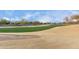 View of a golf course with sand traps and homes in the background at 26686 W Piute Ave, Buckeye, AZ 85396