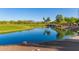 Serene lake with mountain views and lush landscaping at 26686 W Piute Ave, Buckeye, AZ 85396
