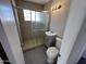 Bathroom featuring a glass door shower, tiled walls, gray vanity and toilet at 2724 W Pierson St, Phoenix, AZ 85017