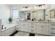 Bright bathroom featuring dual sinks, marble counters, sleek cabinets and a large mirror at 2809 N 82Nd Pl, Mesa, AZ 85207