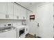 Laundry room with white cabinets, appliances, sink, and hanging rack for convenience at 2809 N 82Nd Pl, Mesa, AZ 85207