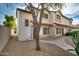 Two-story stucco townhouse with a Spanish-style tile roof, a tree, and walkway at 2955 N Oregon St # 9, Chandler, AZ 85225