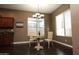 Bright dining area with dark wood-look flooring, a modern light fixture, and natural light at 3337 W Galvin St, Phoenix, AZ 85086