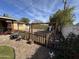 Private backyard features a rustic wooden fence, mature tree, rock, and outdoor seating area at 3341 W Windrose Dr, Phoenix, AZ 85029