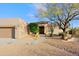 Inviting front exterior with desert landscaping, mature tree, and a covered entrance at 33809 N 67Th St, Scottsdale, AZ 85266