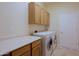 Functional laundry room with a folding counter, cabinets, and modern washer and dryer at 33809 N 67Th St, Scottsdale, AZ 85266