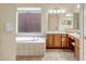 Bathroom with a tiled tub and double sink vanity with matching drawers and cabinets at 41515 N Laurel Valley Way, Anthem, AZ 85086