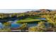 Scenic view of golf course hole featuring water hazard, sand trap and mountain views at 41515 N Laurel Valley Way, Anthem, AZ 85086