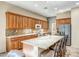 A kitchen with wooden cabinetry, granite countertops, a tiled backsplash, and stainless steel appliances at 41515 N Laurel Valley Way, Anthem, AZ 85086