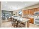 Open kitchen with a large island, wooden cabinets, granite countertops, and modern appliances at 41515 N Laurel Valley Way, Anthem, AZ 85086