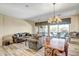 Open-plan living room with wood floors, stylish furniture, chandelier, and sliding glass doors to the outside at 41515 N Laurel Valley Way, Anthem, AZ 85086