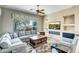 Cozy living room with a large window view, comfortable seating, and built in shelving at 41515 N Laurel Valley Way, Anthem, AZ 85086