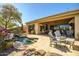 Covered patio and outdoor seating area overlooks the pool with waterfall, set amongst desert landscaping at 41515 N Laurel Valley Way, Anthem, AZ 85086