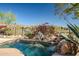 Desert landscaping surrounds a pool with rocks, a small waterfall, and a female sculpture at 41515 N Laurel Valley Way, Anthem, AZ 85086