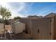 Two storage sheds in a gravel backyard with a mature shade tree and tan privacy walls at 4415 E Weaver Rd, Phoenix, AZ 85050