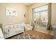 Charming Bedroom with a white crib, patterned rug, chair, and a bright window at 4415 E Weaver Rd, Phoenix, AZ 85050